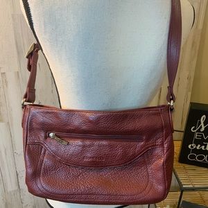 Stone & Co maroon bag with three zipper pockets.